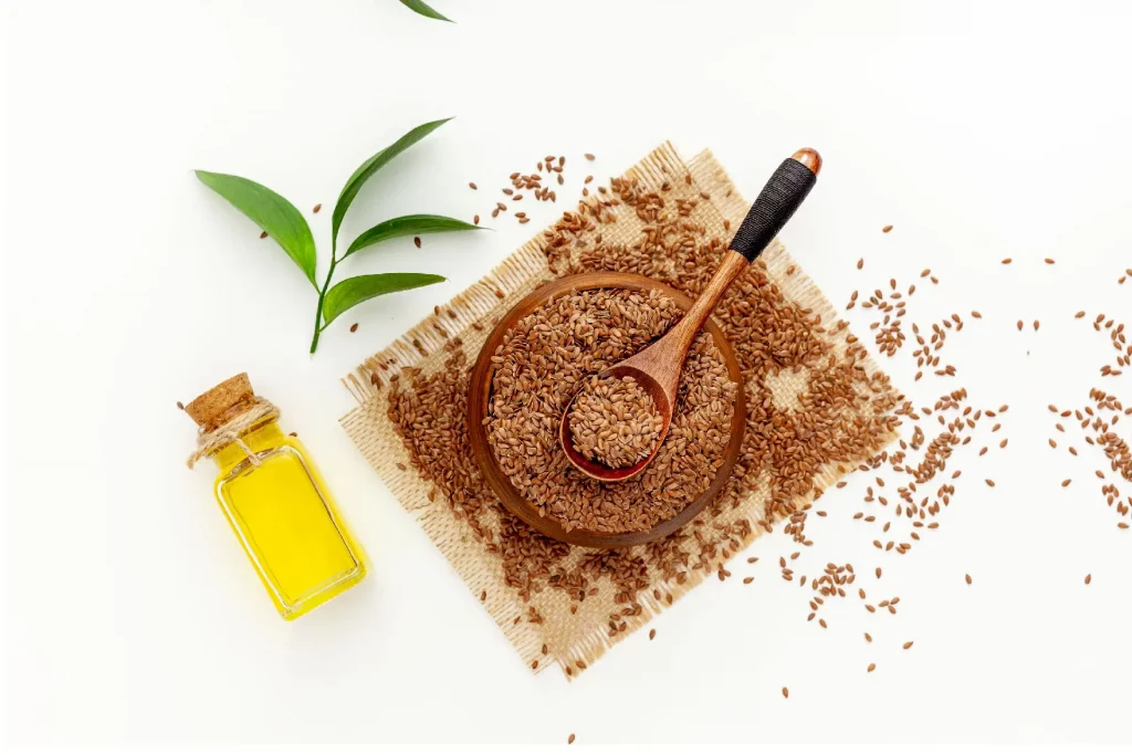 Flaxseeds, oil, and green leaves arrangement