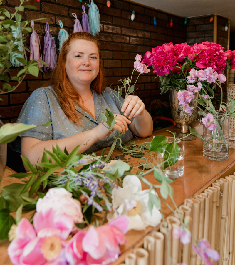 Florist arranging colorful fresh flowers.