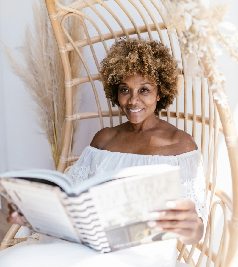 Woman reading a book in a bamboo chair
