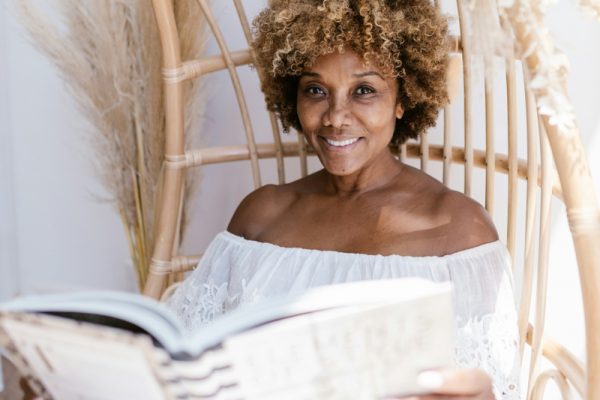 Woman reading a book in a bamboo chair